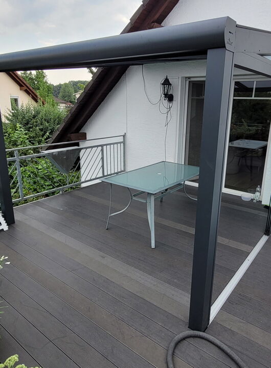 Terrassenüberdachung mit Schiebetüren montiert auf einem Balkon